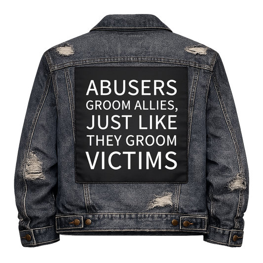Black fabric back patch sew onto a denim jacket with the design "Abusers Groom Allies"