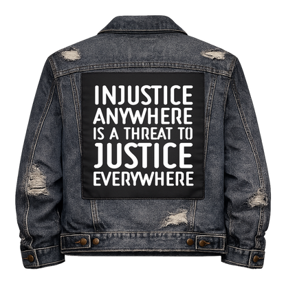 Black fabric back patch sew onto a denim jacket with the design "Injustice"
