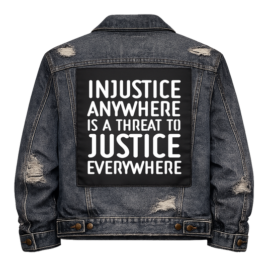 Black fabric back patch sew onto a denim jacket with the design "Injustice"