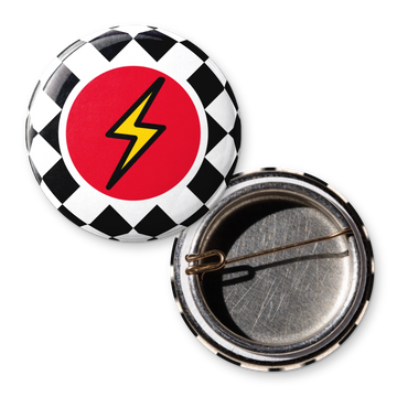 One-off 25mm custom D-pin badge printed with a yellow lightning bolt on a red circle and checkerboard, shown with its open back and D-pin